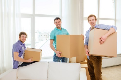 Movers carrying furniture through a Stockwell flat staircase during relocation